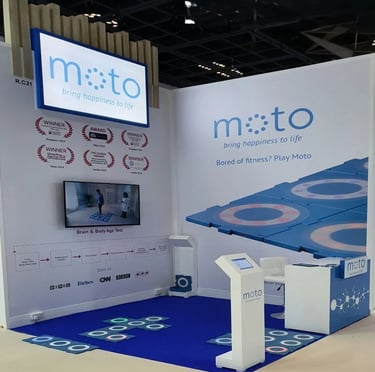 Custom interactive healthcare stand for Moto at Medica Dusseldorf with digital screens and branding by World Expo Pro.