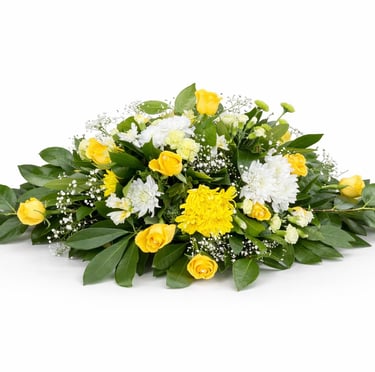 Elegant funeral casket spray featuring yellow roses and white chrysanthemums with green foliage.