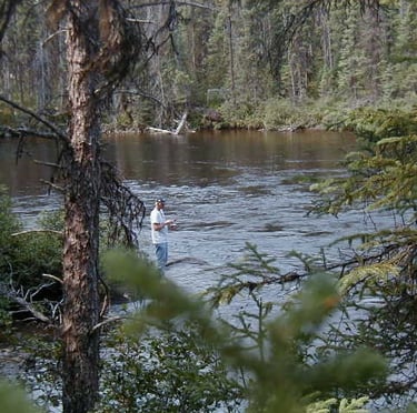a man standing in a river with a fly fishing