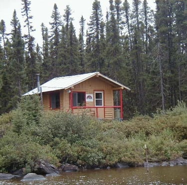 a cabin on a lake with a boat in the water