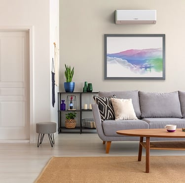 Modern living room featuring a grey sofa, wooden coffee table, and a wall-mounted Bosch air conditioner.