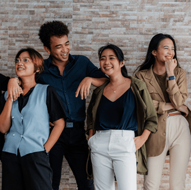 a group of people standing around a brick wall