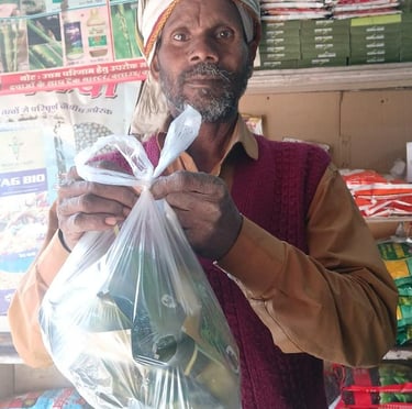 An Indian farmer holding a plastic bag of seeds inside an agricultural supply store.