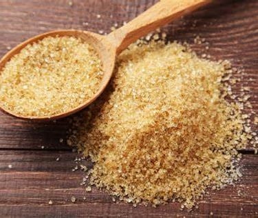 a spoon full of brown sugar on a wooden spoon hamer candy