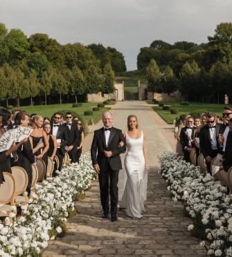 Bride walking down the aisle in lace wedding gown