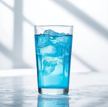 Água solarizada azul servida em um belo copo transparente com pedras de gela em um líquido azulado