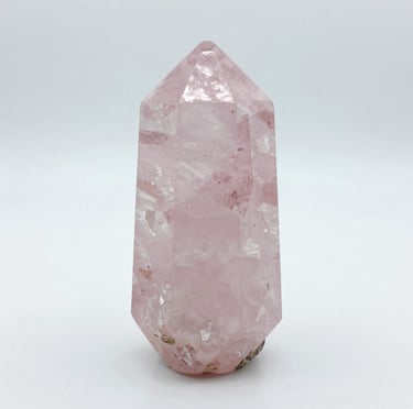 Smooth rose quartz heart-shaped stone resting gently in a palm.