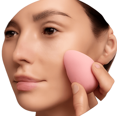 A circular photograph showing a close-up of a person's face while they apply makeup to their cheek with a pink sponge.
