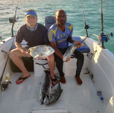 Tourist and local fisherman on a boat with their fresh catches during a Zanzibar fishing game