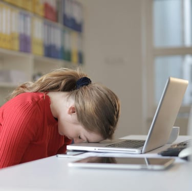 Une femme fatiguée sur sa place de travail et qui illustre l'un des symptome du burn out