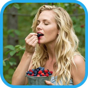 a beautiful woman sensually eating berries in the forest