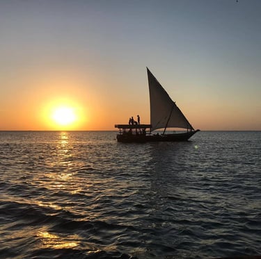 Tourists enjoying a magical sunset on a traditional dhow cruise in Zanzibar, Tanzania.