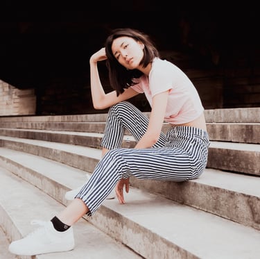 portrait de femme assises sur des escaliers couleurs douces