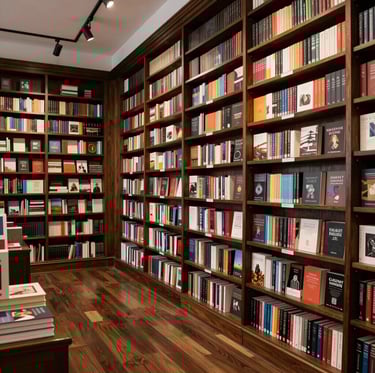 A wide-angle professional photograph of a refined bookstore interior in Maryland, featuring dark wood shelves and a classic, literary atmosphere.