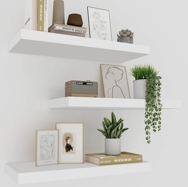 Minimalist white floating shelves featuring modern home decor, potted plants, and framed art.