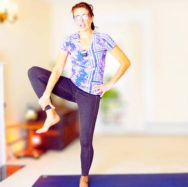 A woman in a yoga studio performing a balance yoga tree exercise