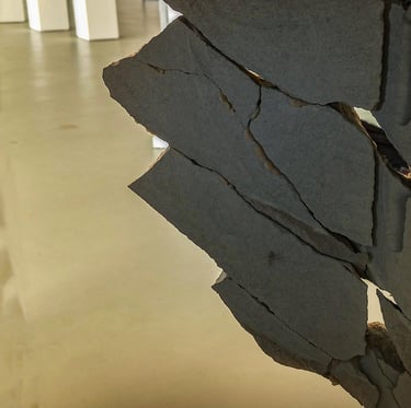 A sculpture of a block of stone broken into pieces and reconstructed like a puzzle in an exhibition