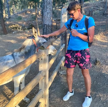 a man with looneytravels t shirt and a donkey