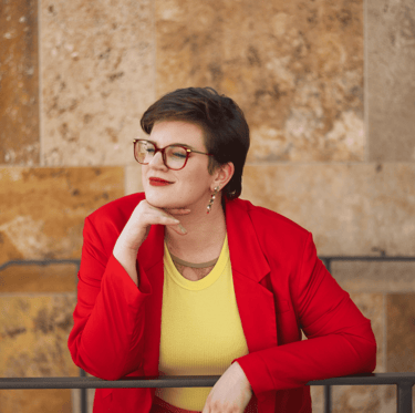 Swana Schuchmann, mit rotem Blazer. Sie schaut in die Ferne.