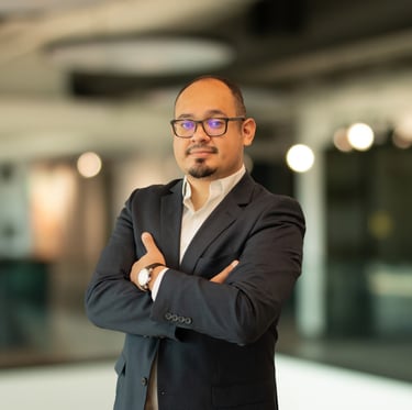 a man in a suit and glasses standing in a room