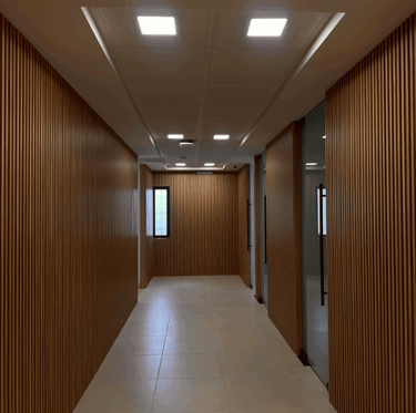 Pasillo con acabado de madera en muros y plafón con luminarias LED | KARÄNA