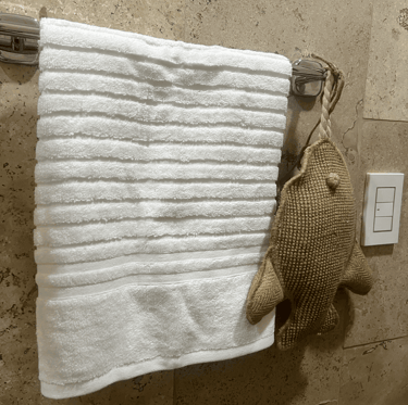Decoración costera con textura suave y acento artesanal en baño con muros de piedra natural | KARÄNA