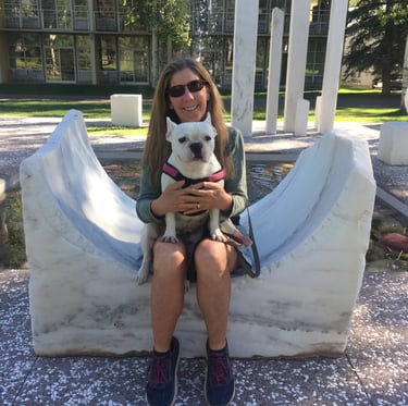 a woman sitting on a bench with a dog