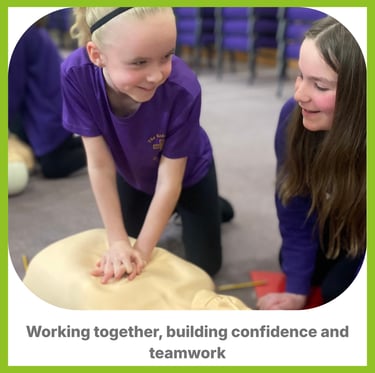 A child learning CPR on a manikin smiling at another child next to her