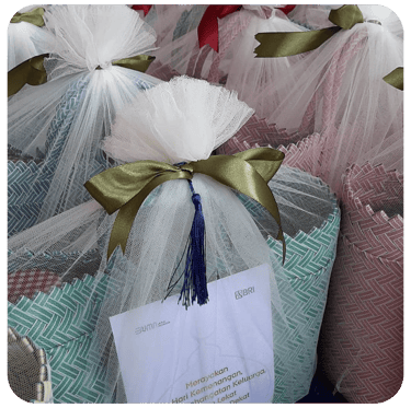 Premium handmade woven bag souvenirs wrapped in elegant tulle gift packaging.