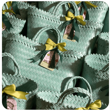 Custom mint green handmade woven bags prepared as corporate gift souvenirs.