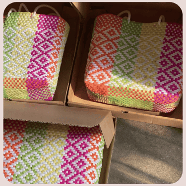 Colorful patterned woven plastic bags packed in boxes for bulk export and wholesale distribution.