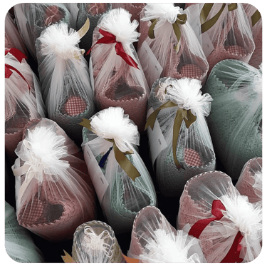Elegant woven plastic souvenir bags wrapped in tulle fabric for premium gift presentation.