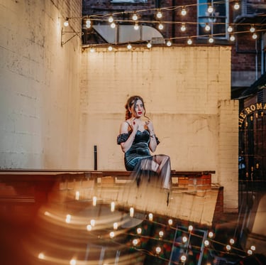 Bride posing under string lights in a York courtyard, captured by Fred Art Studio.