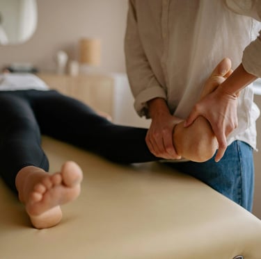 Une femme bénéficie d'une séance de réflexologie plantaire dans une pièce apaisante, entourée d'une ambiance calme.