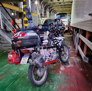 a motorcycle parked in a garage with a lot of luggage