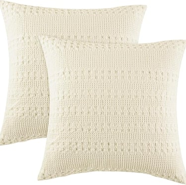 Creamy white cotton pillow covers for cozy minimalist bedroom comfort.