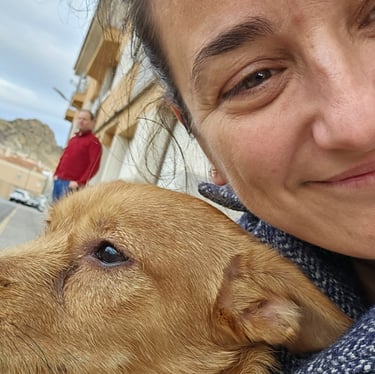 a woman in a blue jacket is holding a dog