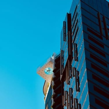 Modern building facade with geometric architectural details against a clear blue sky
