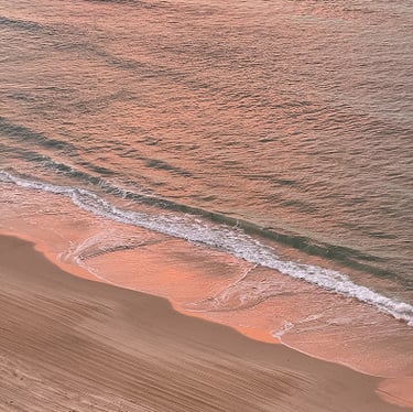 un atardecer rosado reflejado sobre el agua del mar
