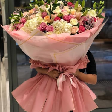 a woman holding a giant bouquet of flowers 