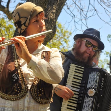 Mazel Tov Kocktail Hour founders playing flute and accordion at a show.