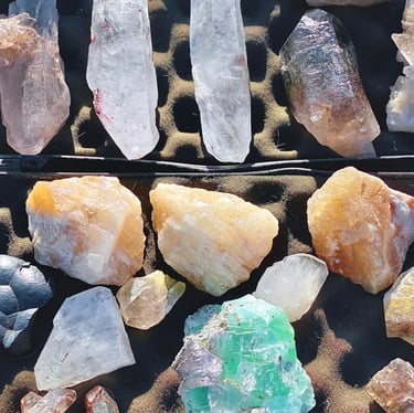 Colección de cristales curativos crudos que incluye puntas de cuarzo, citrino y fluorita.