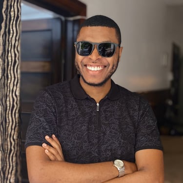 a man in sunglasses smiling and folding his arms