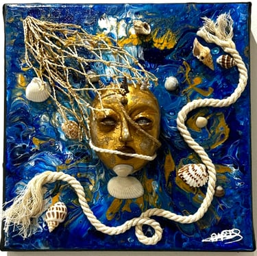 un visage d'or sculpté qui émergent des eaux marines