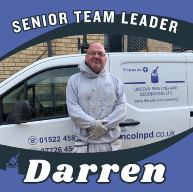 Portrait of Darren, a senior team leader, smiling and standing next to his branded van.