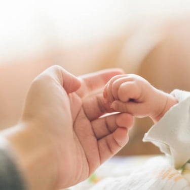Main d'un bébé et de sa maman