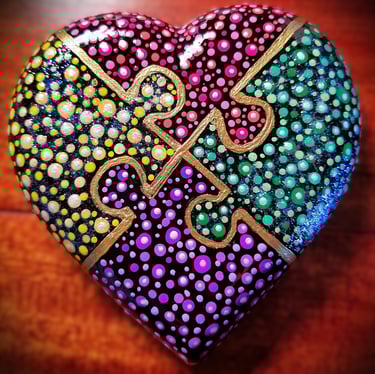 heart rock with 4 puzzle pieces in red, yellow , purple and green dots. 
