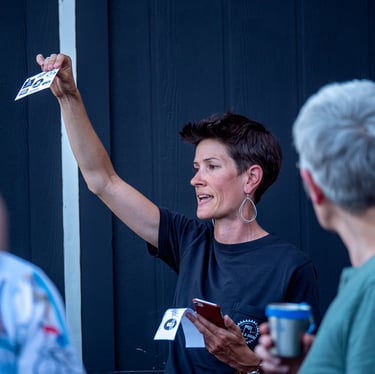 Woman in grey shirt speaking to a group