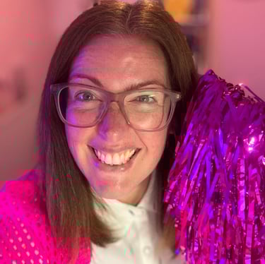 Gabi holding a pink pom pom, to welcome you to sign up to her newsletter, the leopard pages. 