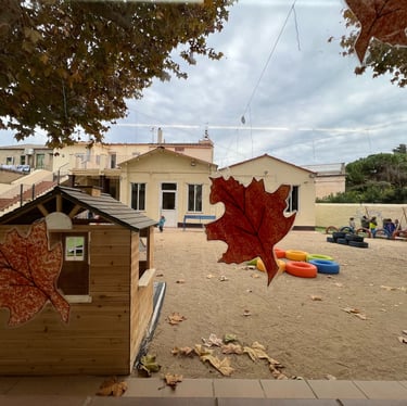 Pati de l’escola amb una caseta i fulles de tardor / Patio de la escuela con una casita y hojas de o